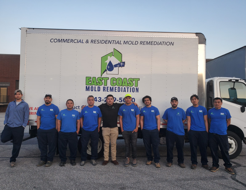 East Coast Mold Remediation team wearing company shirts in front of a company truck.